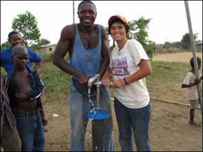 Jessica Lay helps provide water to rural villages. She's pictured with a native Sierra Leonean who helps with well drilling. The well will provide drinking water and irrigation water for a nearby farm.